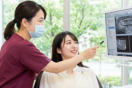 レントゲンで説明する歯科医師